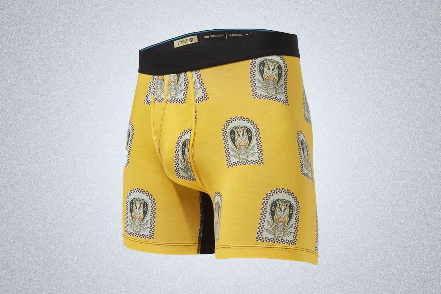a pair of yellow and patterned stance boxer briefs with a black waistband on a gray background