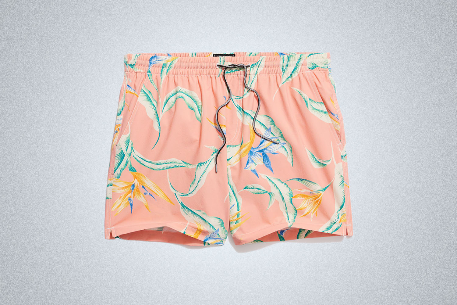 a pair of pink patterned swim trunks on a grey background