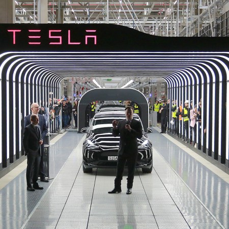 Tesla CEO Elon Musk stands in front of a line of Model Y vehicles during the opening of the EV company’s German factory Giga Berlin on March 22, 2022.