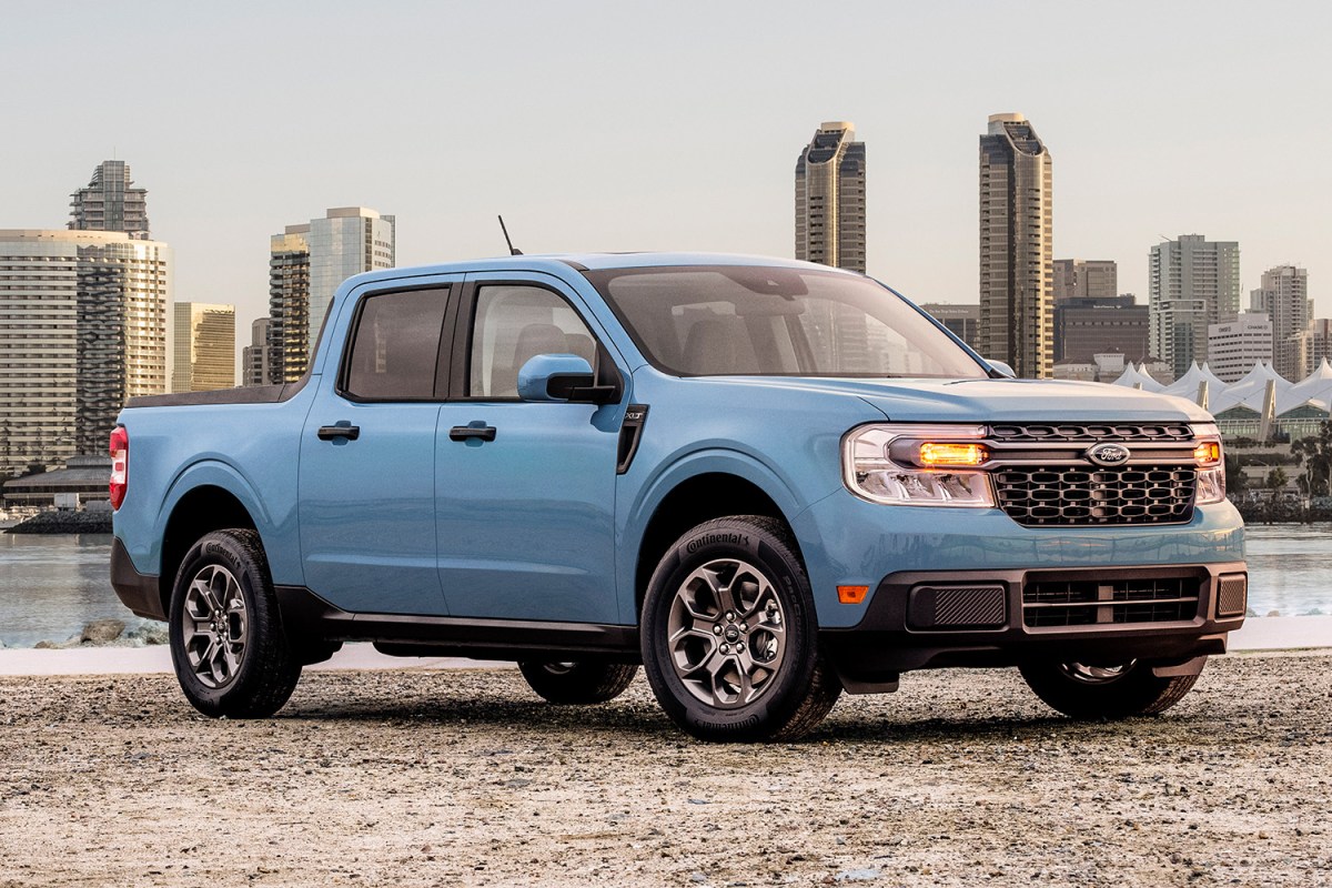 The 2022 Ford Maverick in blue sitting in front of a city skyline. We tested and reviewed the pickup and found a lot to love.