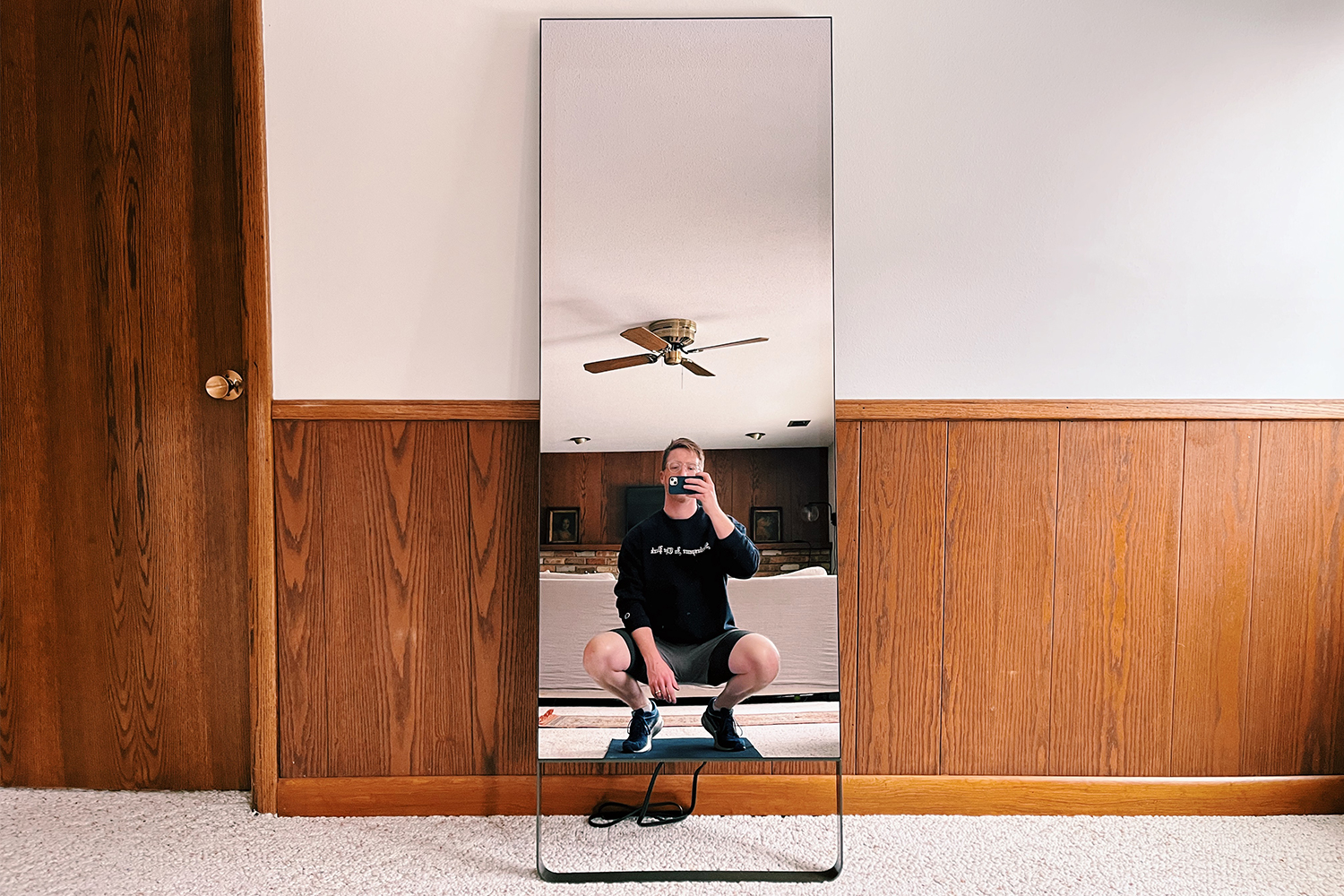 The original exercise mirror, from Mirror, leaning up against a wall at home. We reviewed the home fitness machine to find the pros and cons.