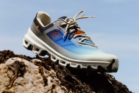 A shoe from the On x Loewe running collection sitting on a rock. We take a look at the Cloudventure shoe and the other gear.