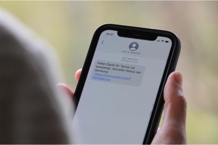 A woman holds a smartphone in her hand with a scam text message on the display. With so-called smishing, criminals rely on consumers clicking on the link sent with the text message and then unknowingly downloading malware.