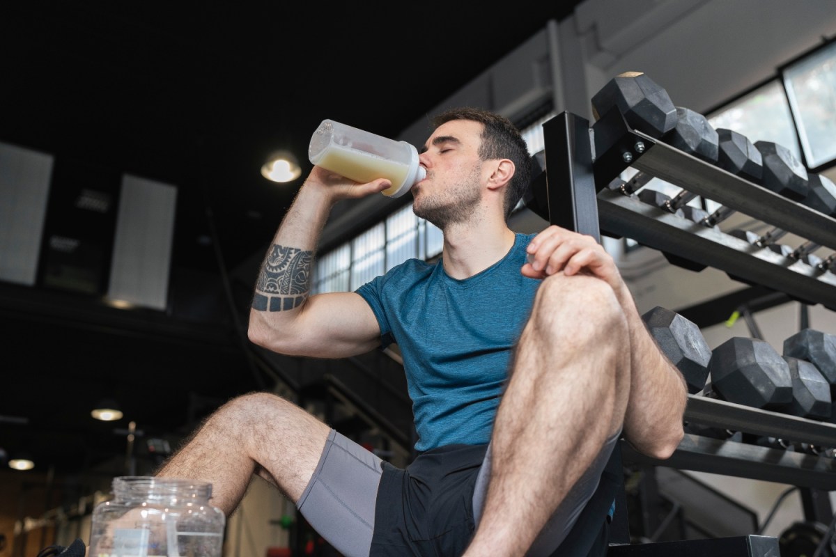 Male athlete drinking protein shake while sitting in gym. A new study found that high-protein diets could lead to lower levels of testosterone in men.