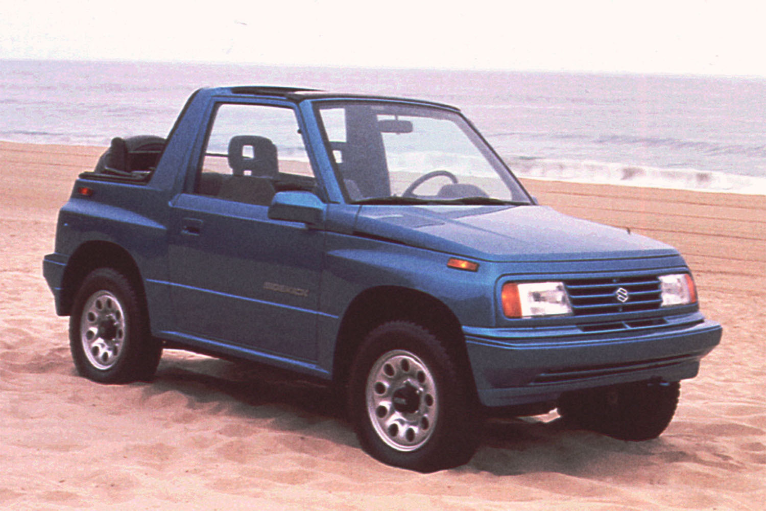 The Suzuki Sidekick in blue on the beach