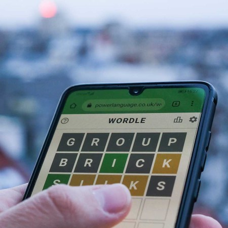 A person playing the daily word game Wordle on their phone. A new study reveals which states cheat at Wordle the most.