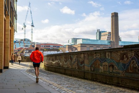 A man runs along a canal in London. If you're having trouble making time for workouts during the week, consider "exercise snacking."