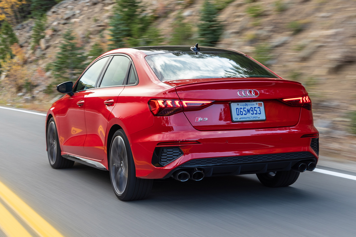 The 2022 Audi S3 in red driving down the road, shown from the rear end