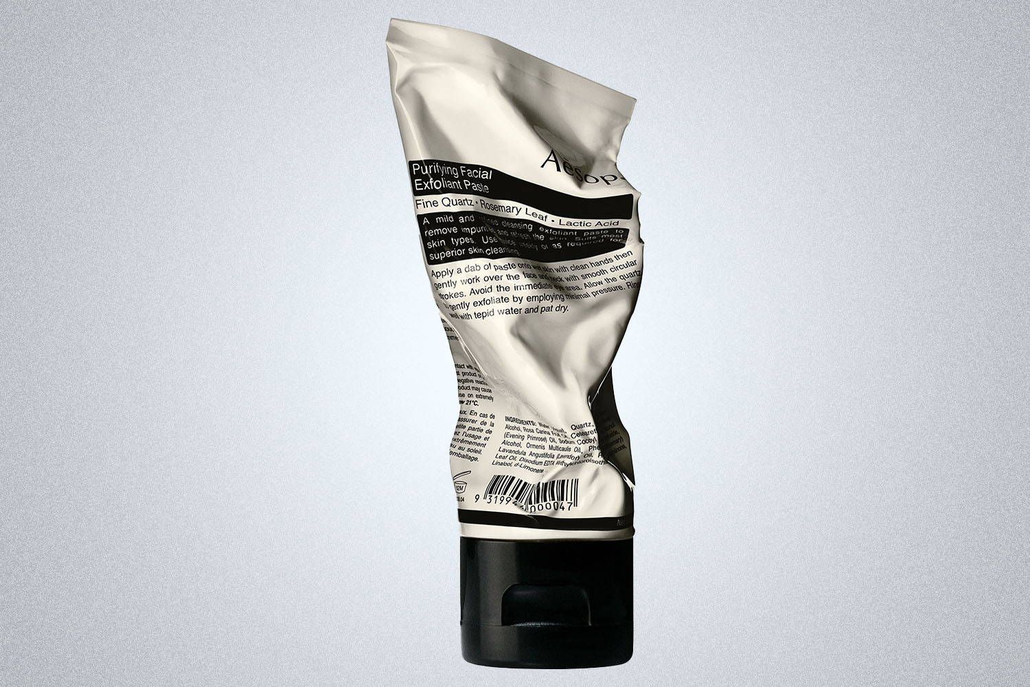 a Aesop skincare product on a grey background