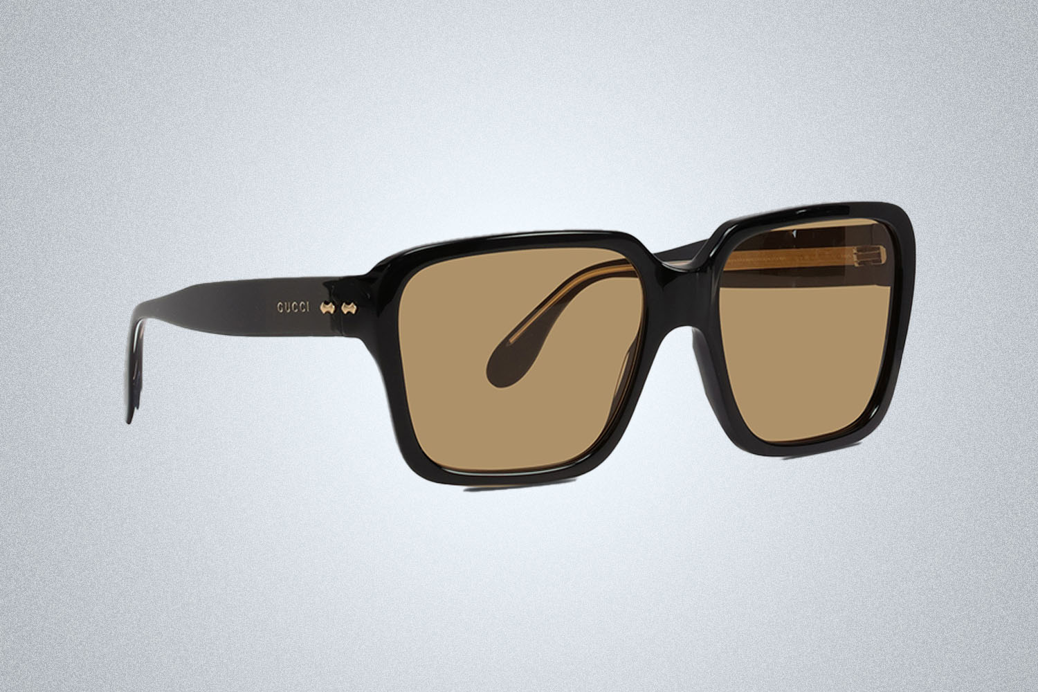 a pair of designer sunglasses from Gucci on a grey background