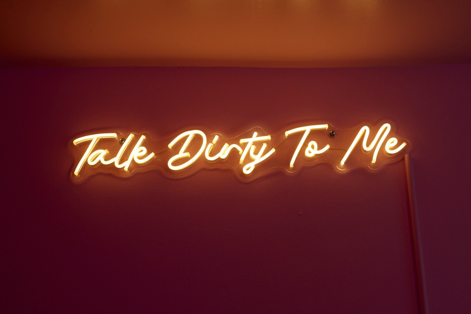 Neon wall art in Kinky's upstairs lounge reads "Talk dirty to me."