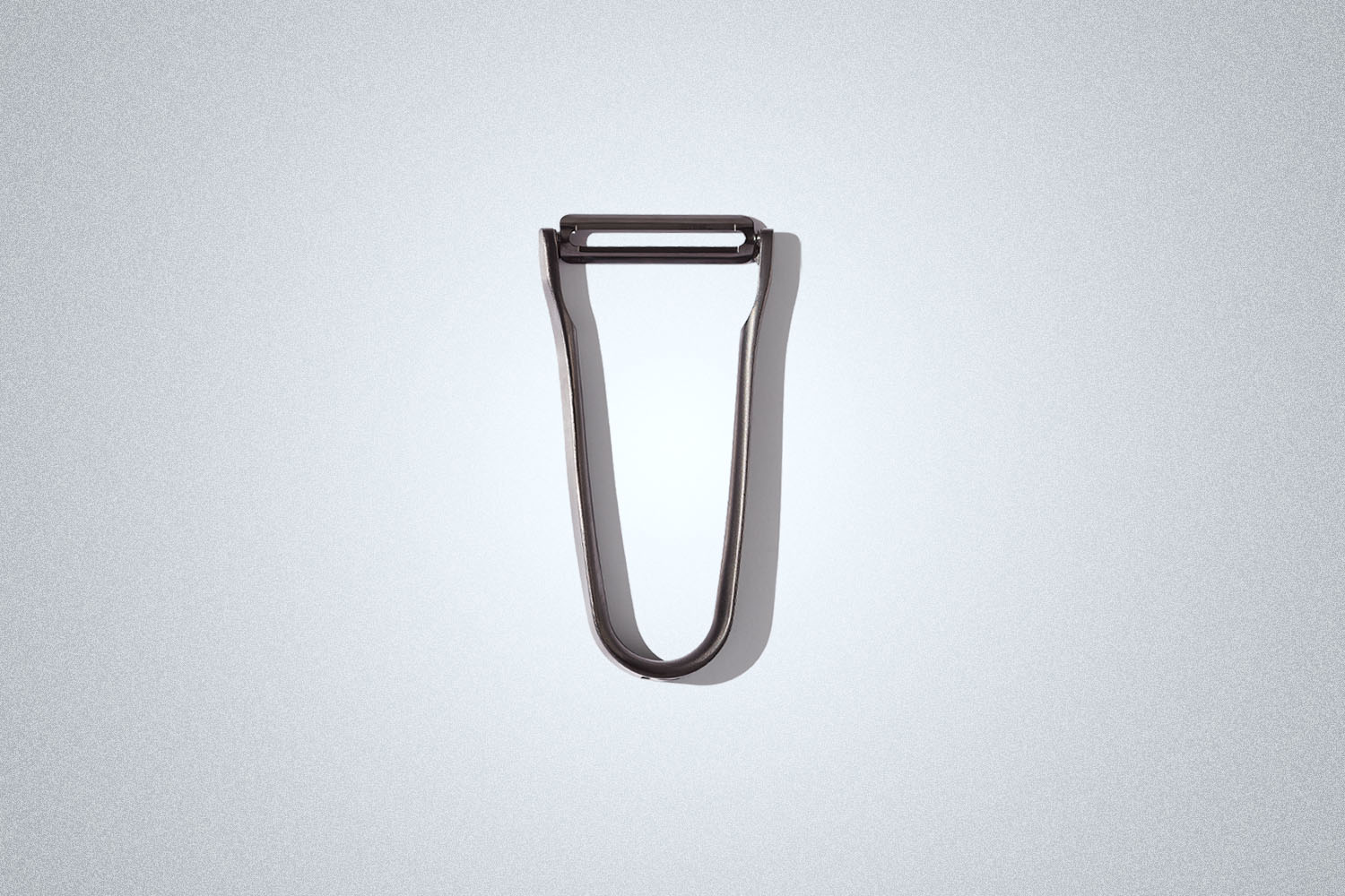 A silver peeler on a grey background
