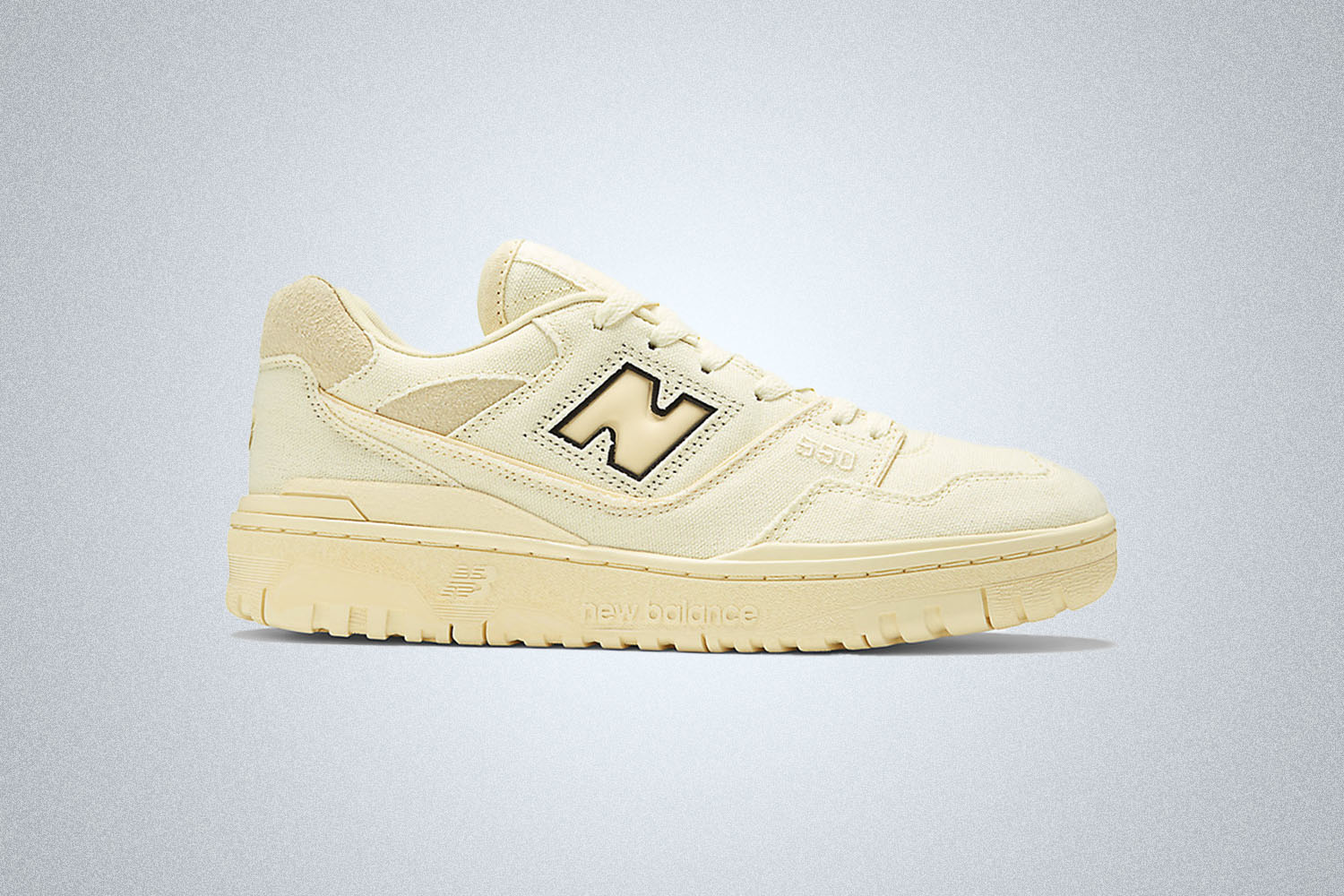 An off white New balance 550 sneaker on a grey background