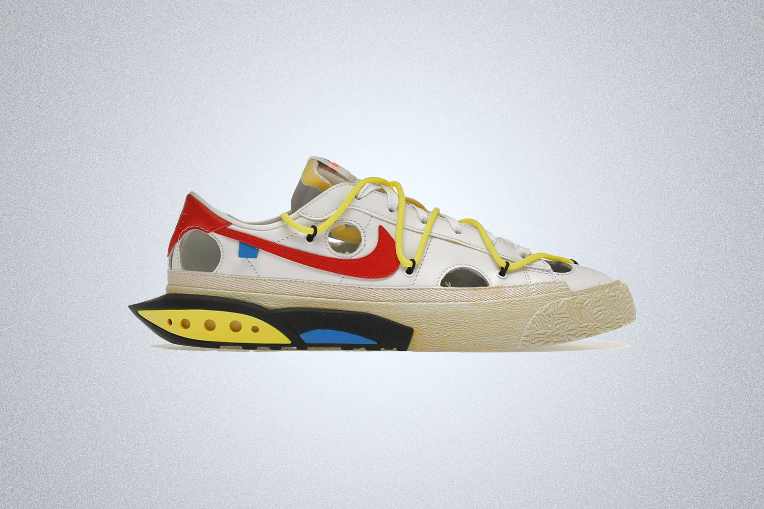 A Nike x Off White Sneaker with "" branding and holes cut out of the frame on a grey background