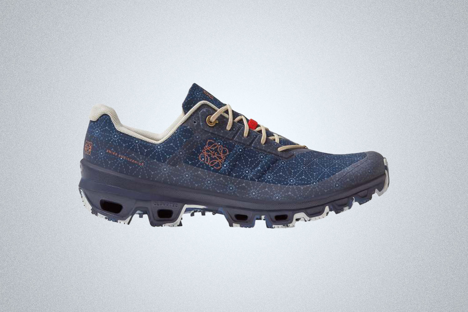 a blue, grey and galaxy-patterned trail shoe from On Running on a grey background 