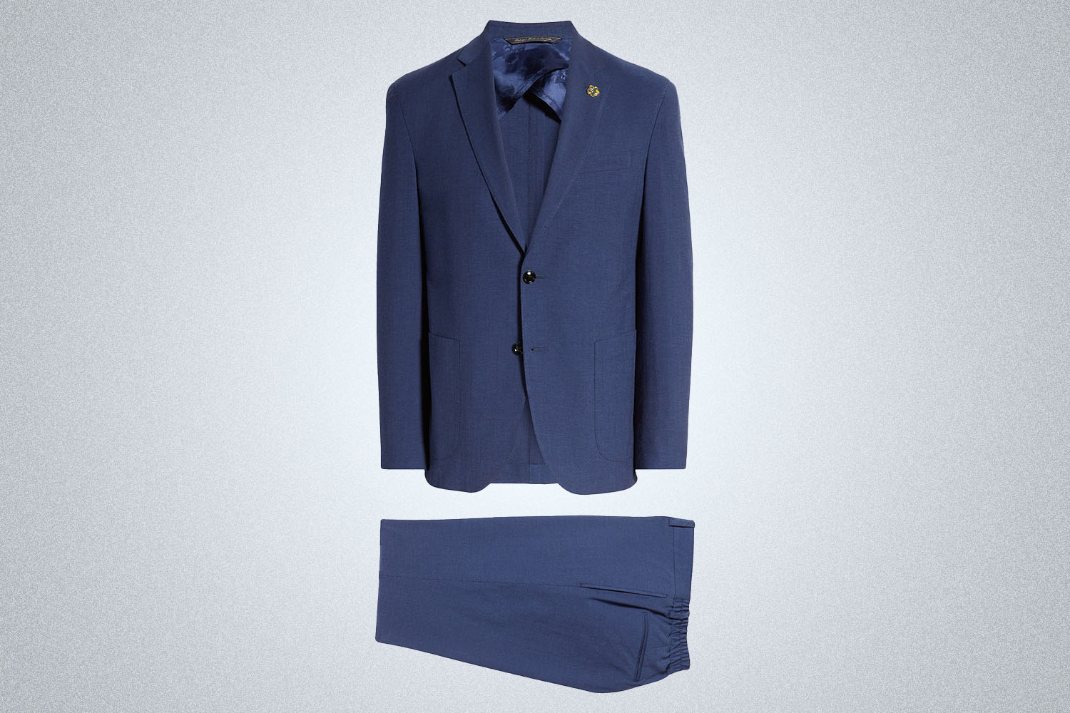 A blue Ted Baker London suit jacket and pants on a grey background