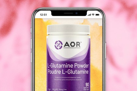 A tub of L-Glutamine Powder in an iPhone on a pink background.
