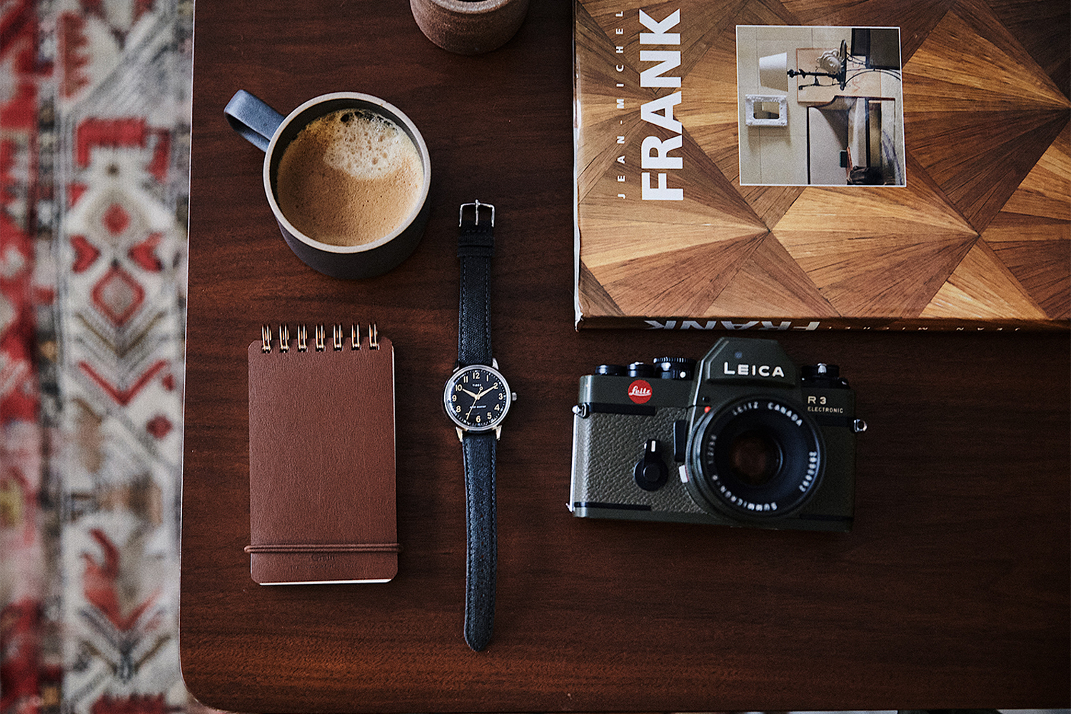 a watch with other items on a wooden table