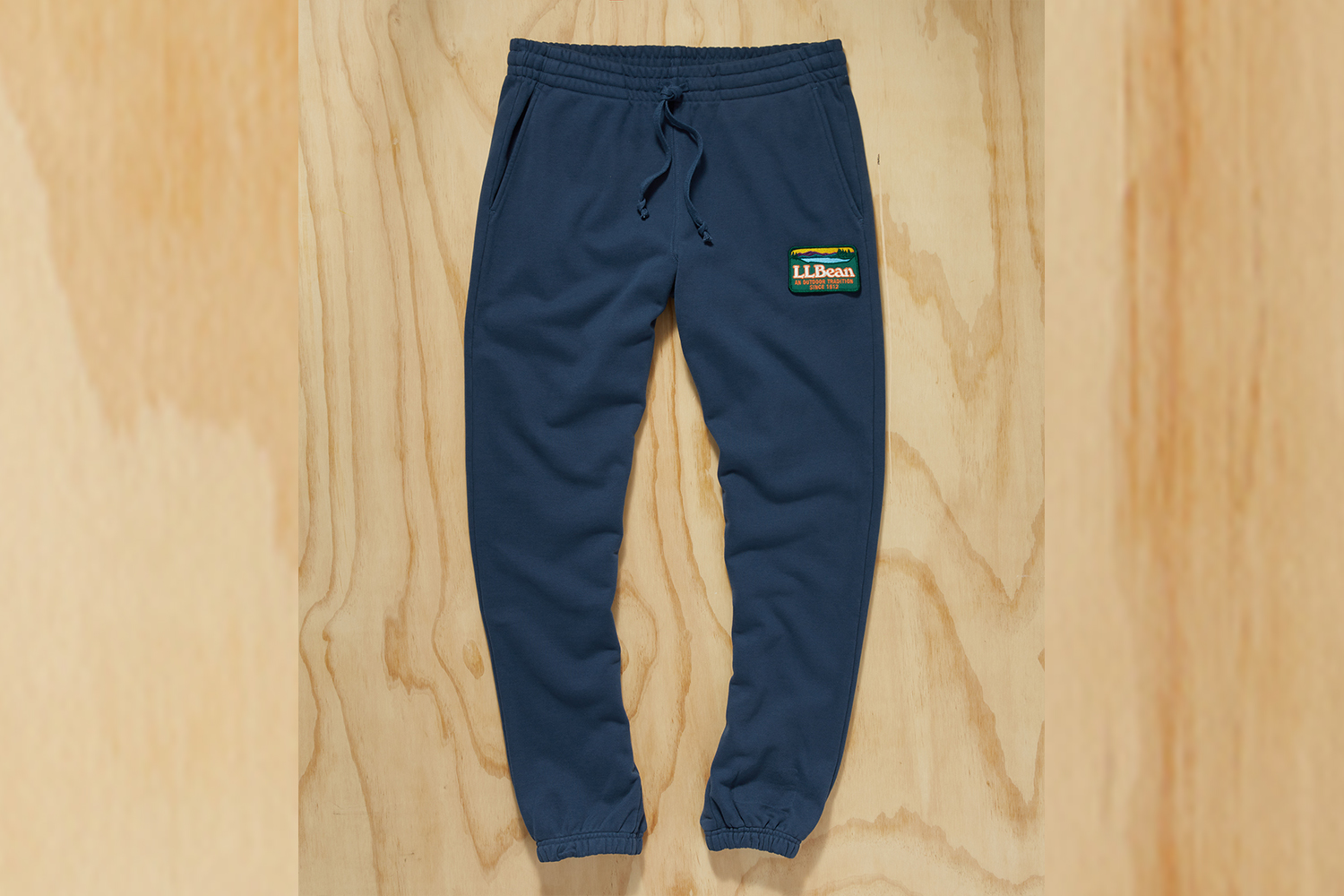 a pair of blue sweatpants on a wood background