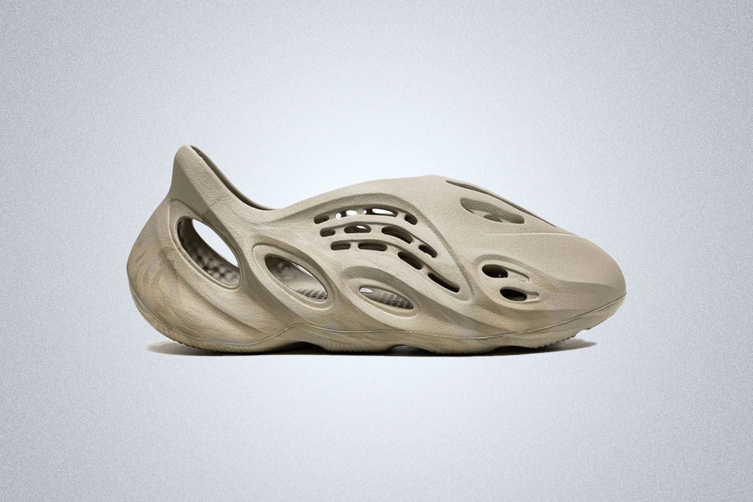 A pair of beige Yeezy Foam Runner Sneakers on a grey background