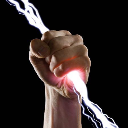 Close up image of man's fist holding a bolt of lightning