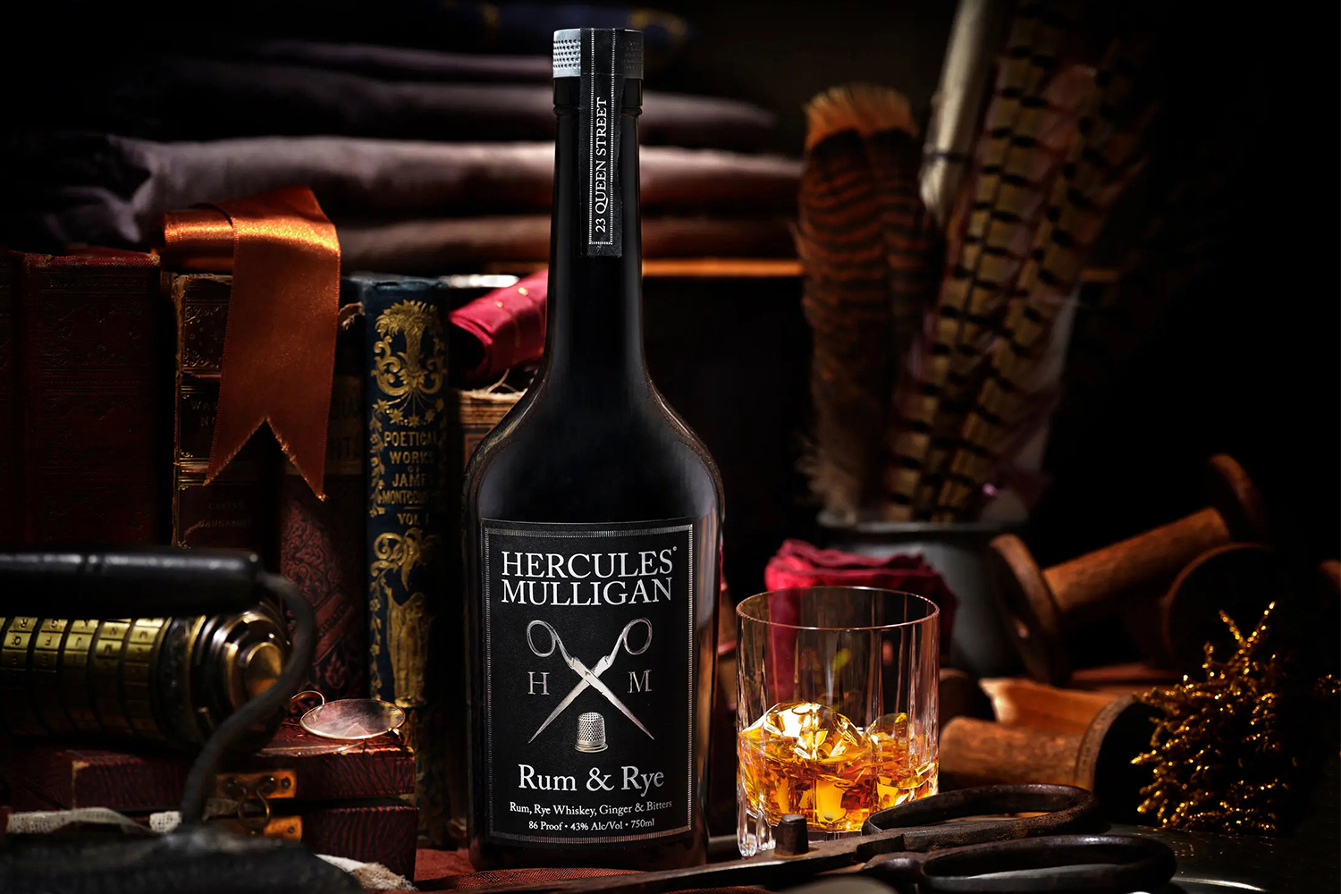 A bottle of the new rum/rye Hercules Mulligan near a drinking glass. We reviewed the drink and found it works best as a base spirit.