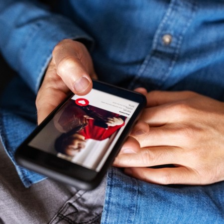 Close-up of a man using an online dating app on his mobile phone. Cropped shot of a man hand holding a cell phone using an online dating application.