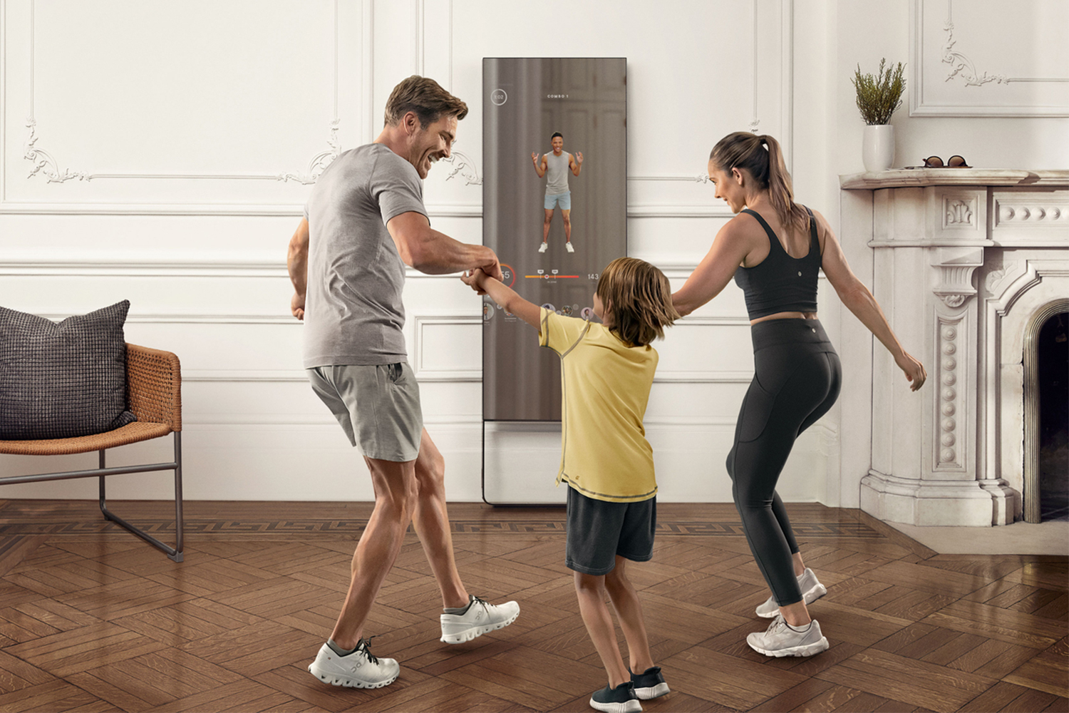 A mum, dad and young son working out with the Mirror, a home fitness machine.  The exercise program includes "Family fun" courses intended for children under the age of 12.