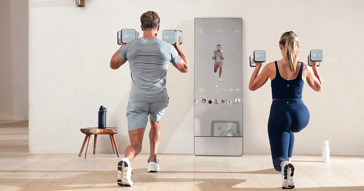 A woman and man working out with the Mirror, a home fitness device embedded in a reflective mirror. We take a look at why the home gym is the perfect Mother's Day gift for 2022.