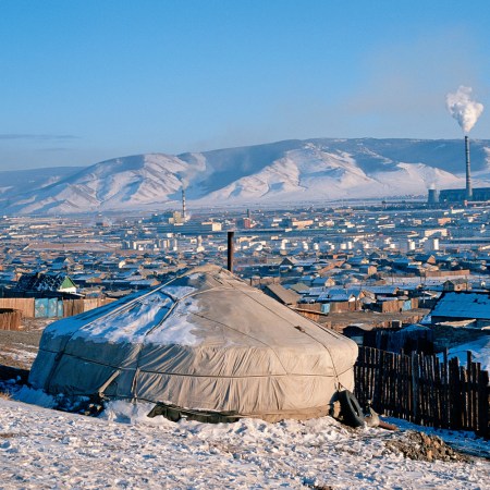 A traditional yurt in Ulaanbaatar, with factory smoke in the background.