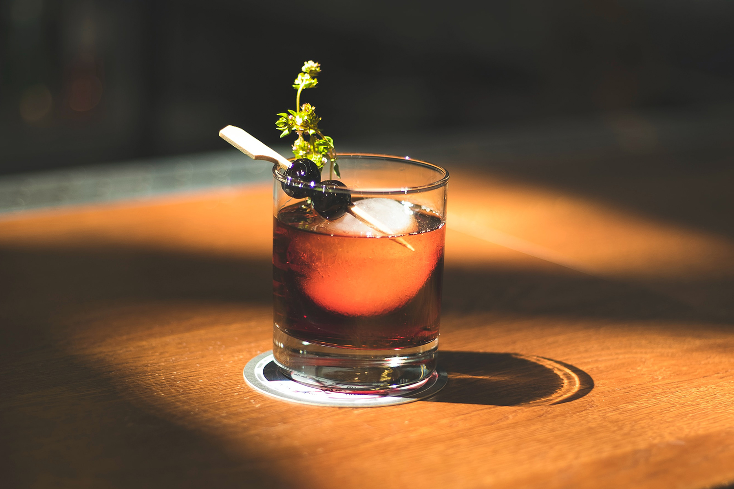 A cocktail garnished with two cherries sitting on a bar in the sunlight. Here's how Austin's Chris Marshall took his sober bar concept Sans Bar nationwide.
