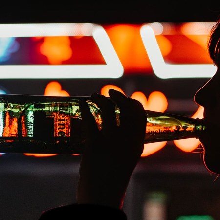 A woman drinking a Heineken in a dark room Are you a grey area drinker? The term has come up more as people consume more alcohol during the pandemic..