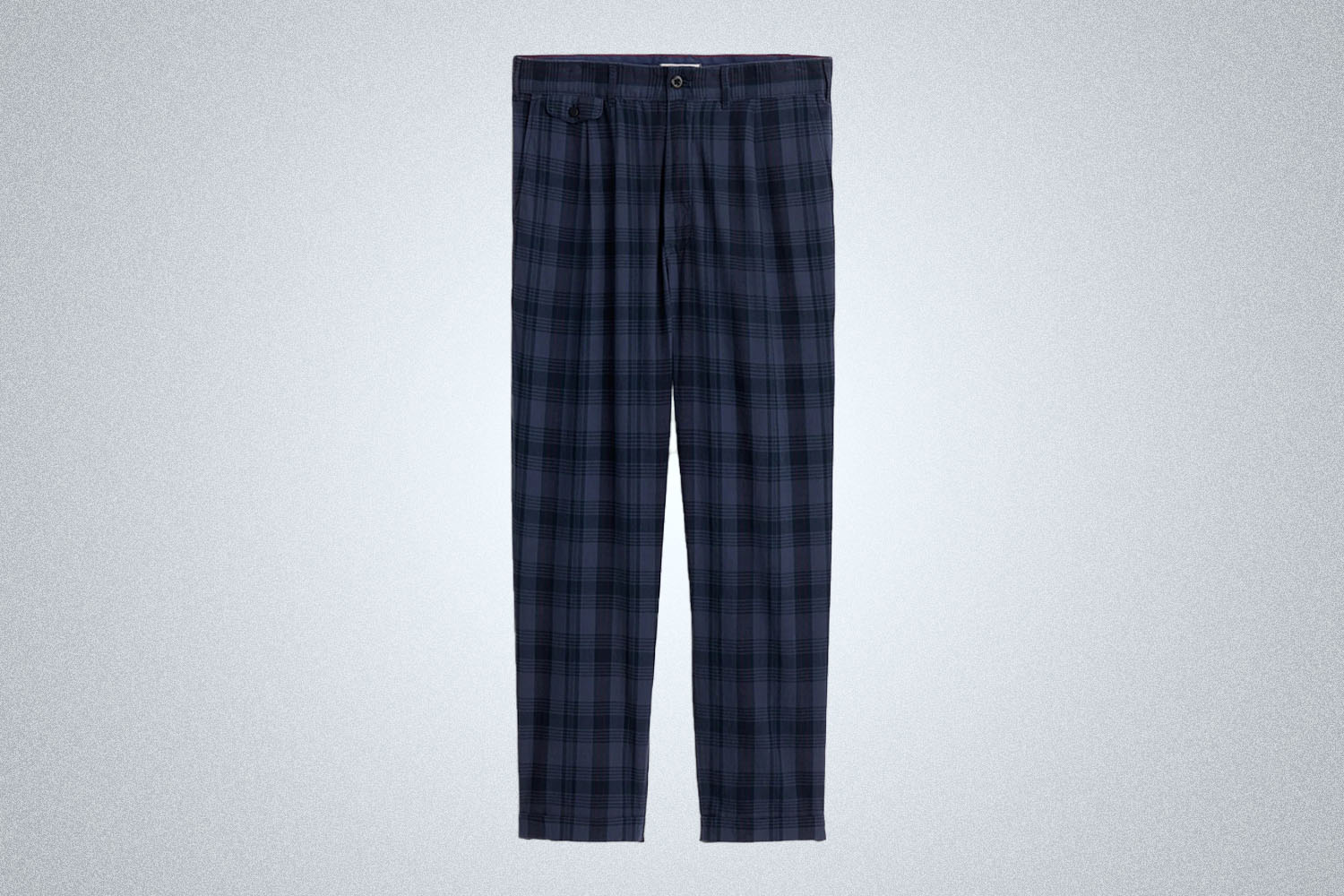 a pair of blue madras pleated pants from Alex Mill on a grey background