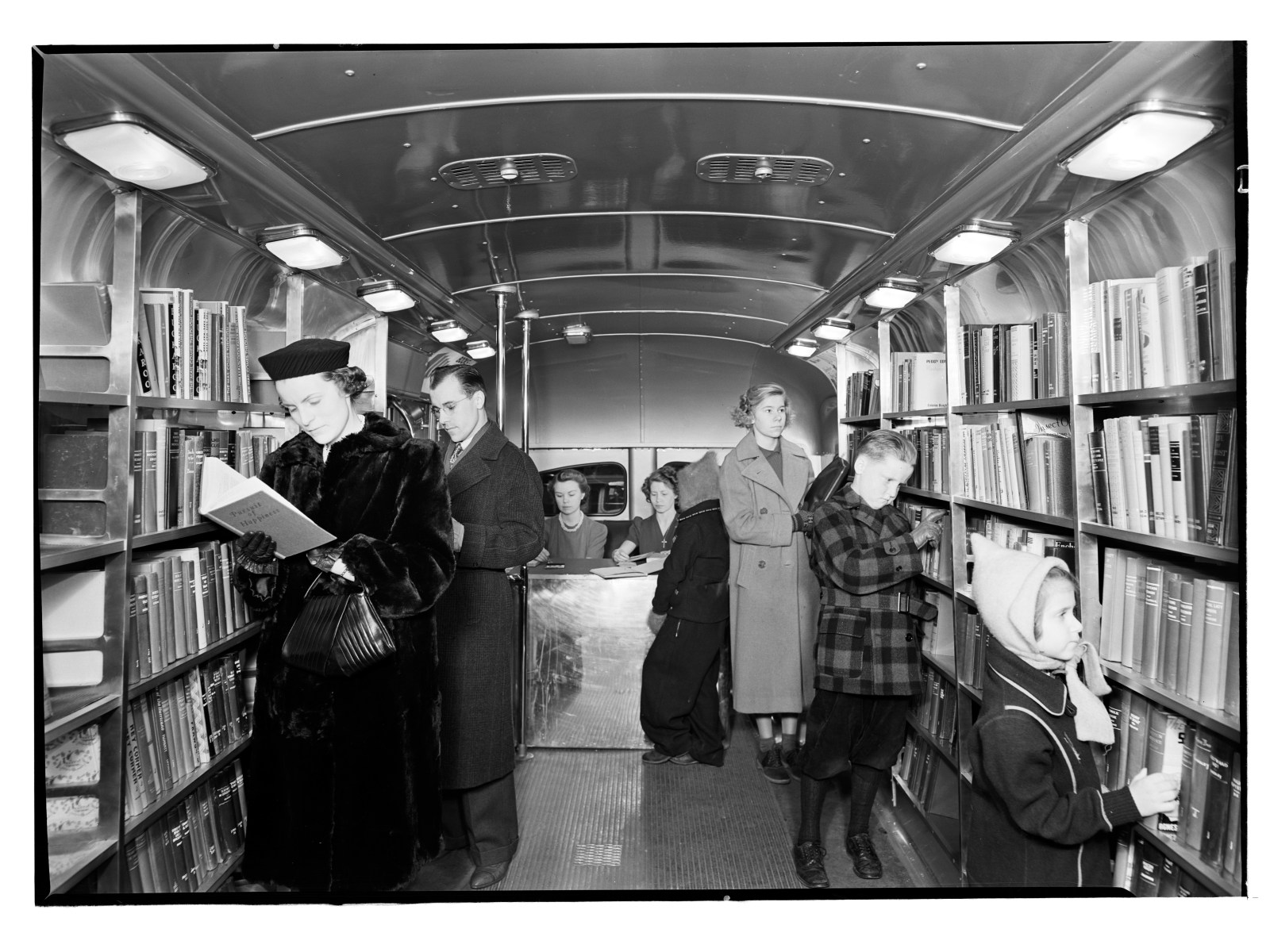This is a bookmobile, basically a bus full of books, in Queens. There was a giant library in the middle of Manhattan, but Queens and Brooklyn actually had their own independent library systems. As the city was growing, the library networks needed to grow to expand with it. Bookmobiles were the way that growing neighborhoods in Queens and parts of Staten Island were accessed. Today, libraries exist as digital resources that can be accessed from anywhere in the world. At the time this was an incredibly ambitious project to bring books, knowledge and information to a vast and diverse population.