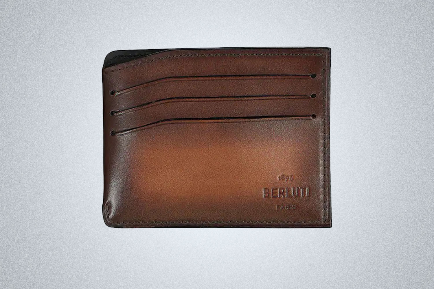 A leather wallet from Berluti on a grey background