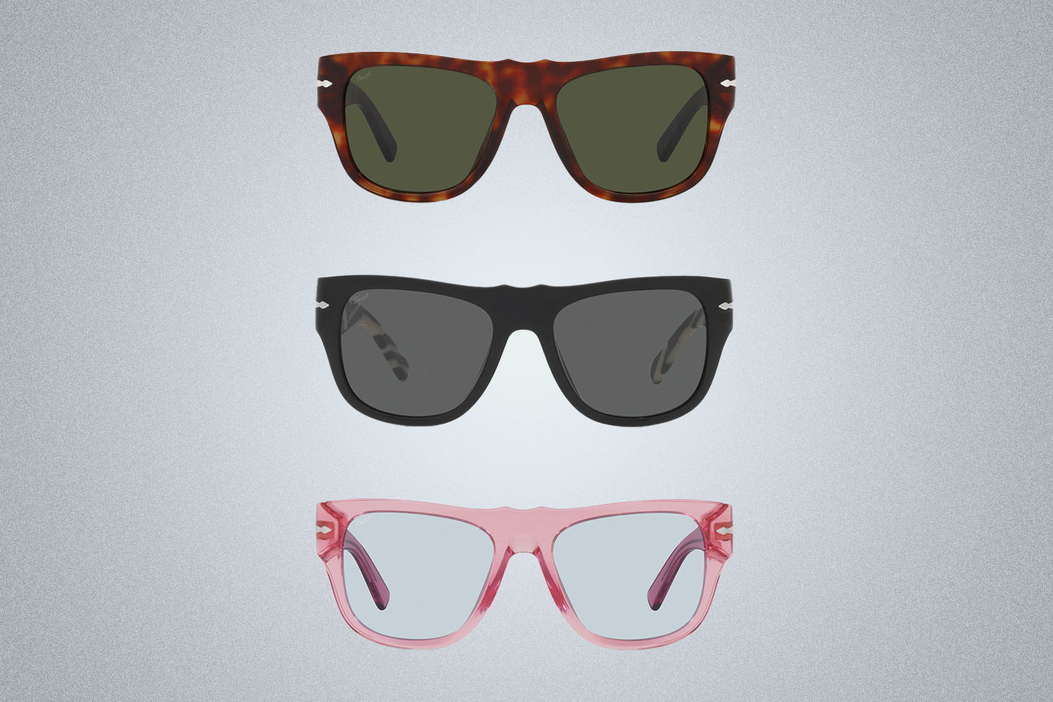 A trio of different colored Dolce&Gabbana x Persol sunglasses on a gray background