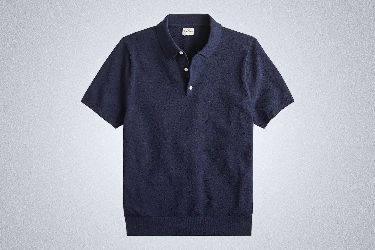 a navy sweater polo from J.Crew on a grey background