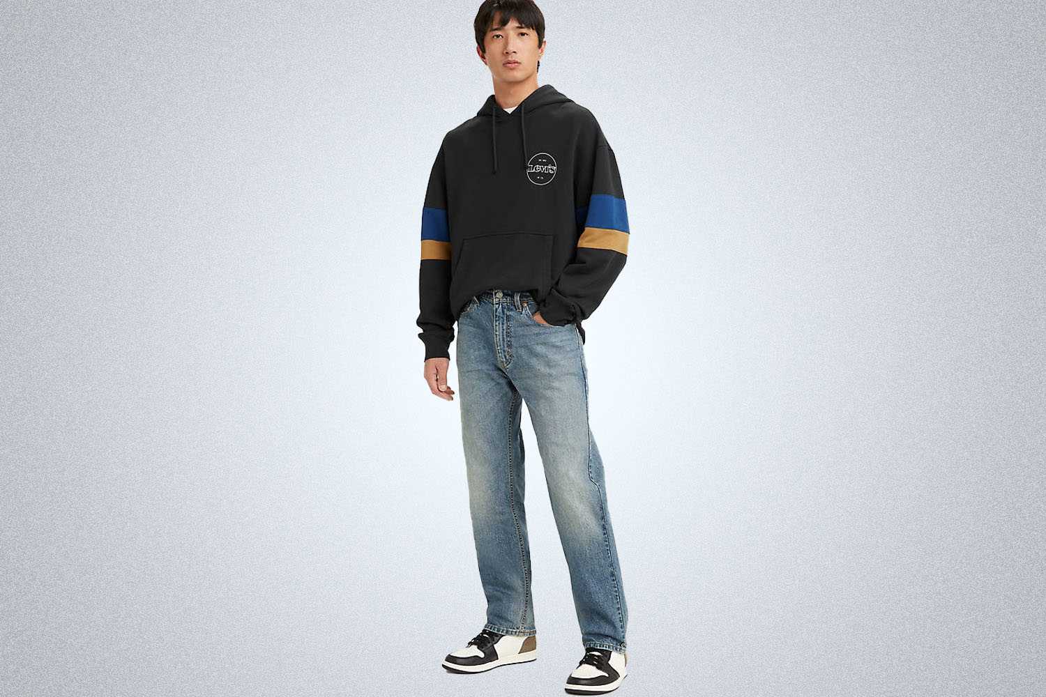 A model wearing Levi's apparel on a grey background 