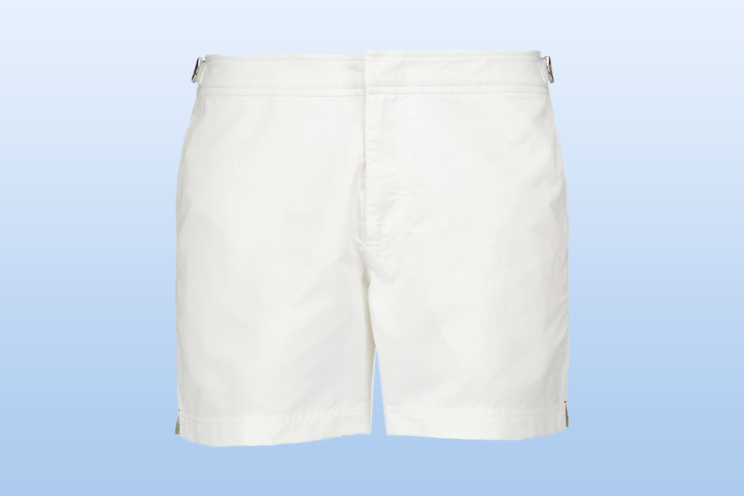 Pair of white swim trunks from mytheresa on a light blue background