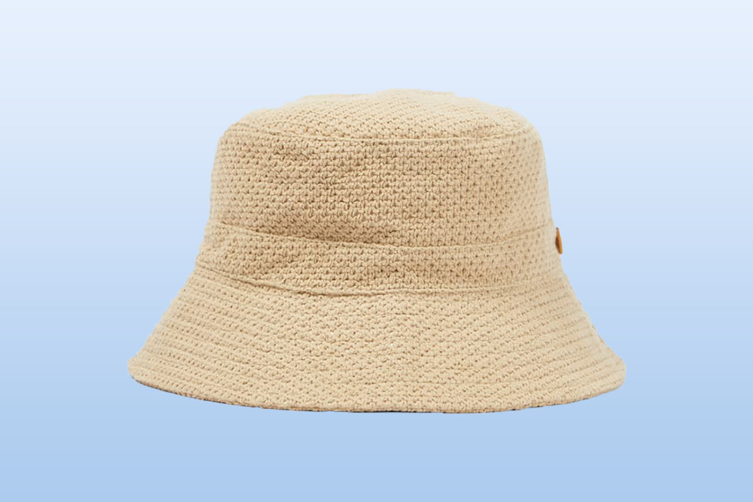 a beige bucket hat from mytheresa on a light blue background