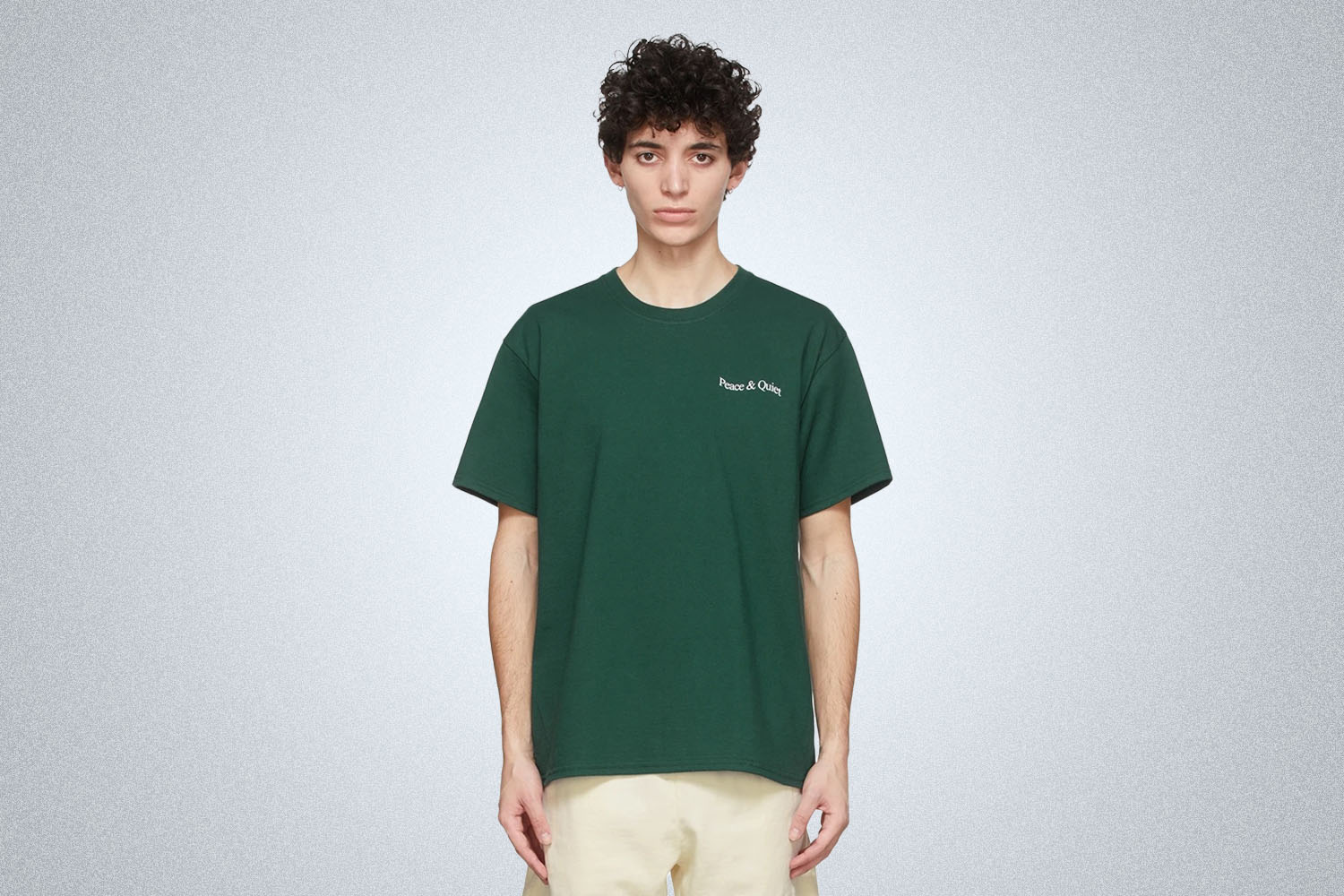 A model in a green MOPAQ tee on a grey background 