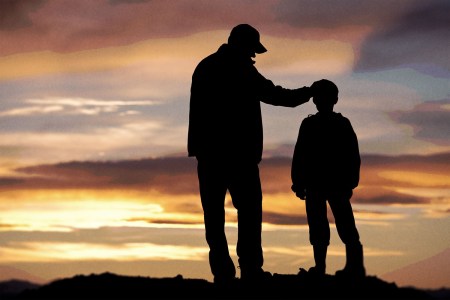 Silhouettes of a father and son at sunset