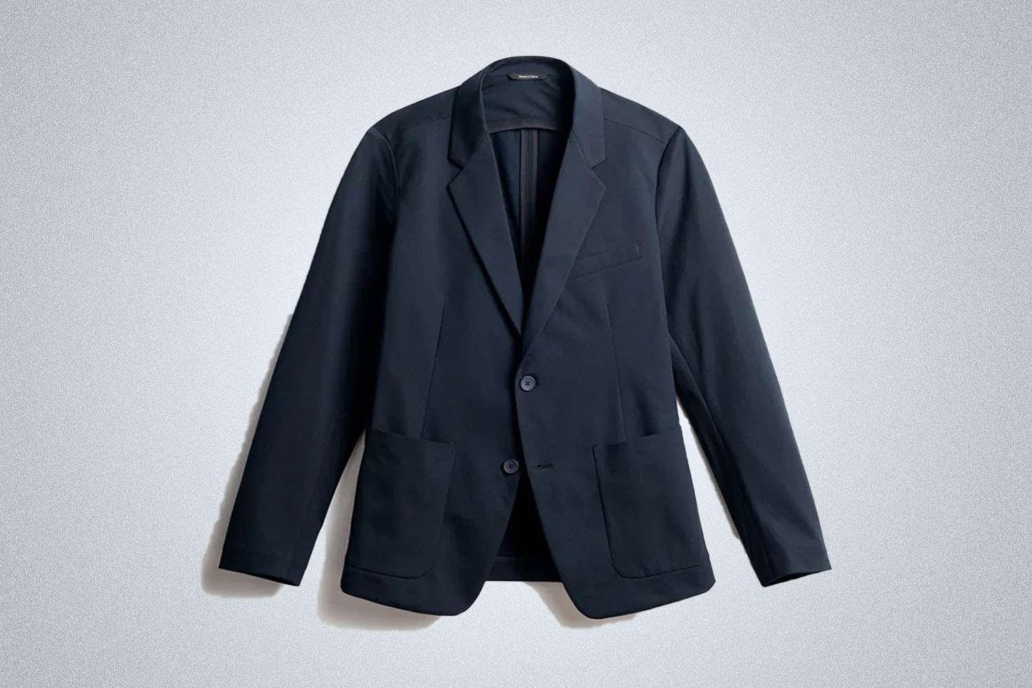 a blue blazer from Ministry of Supply on a grey background