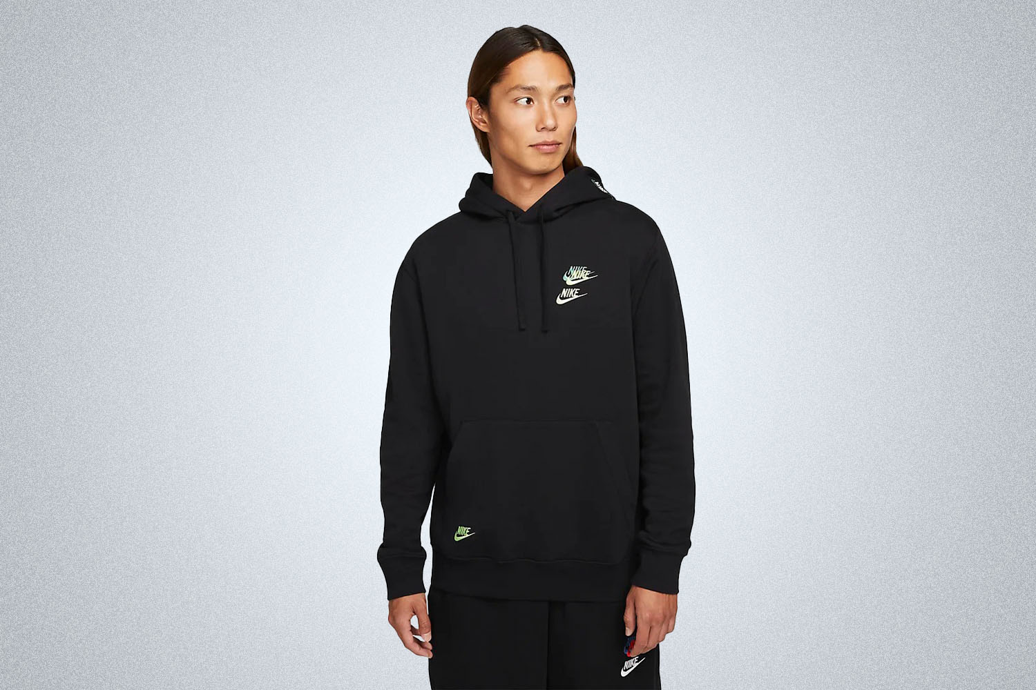 a model in a black nike hoodie on a grey background