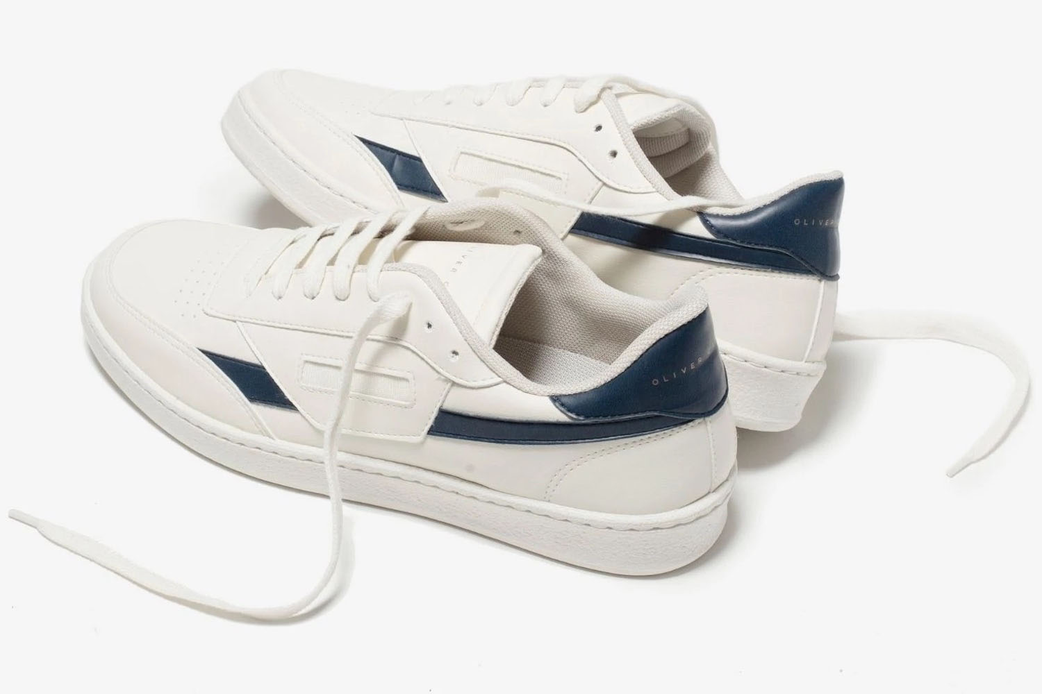 a pair of white sneakers with blue accents from Oliver Cabell on a white background