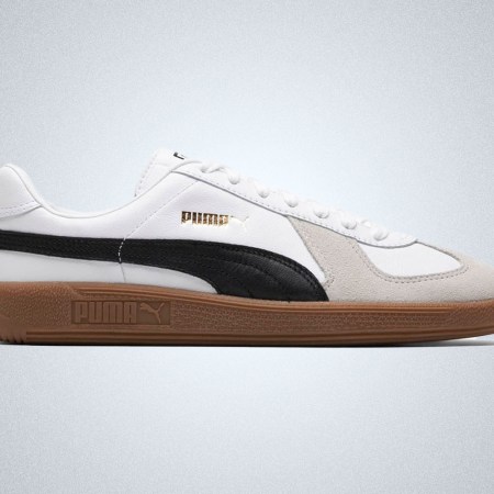 A pair of white sneakers with grey detailing and a gum sole from Puma, on a grey background