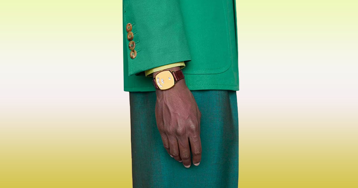 A model wearing a Gucci watch on a gradient background