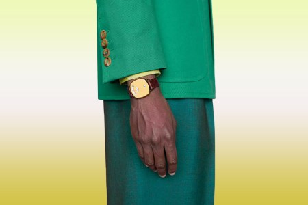 A model wearing a Gucci watch on a gradient background