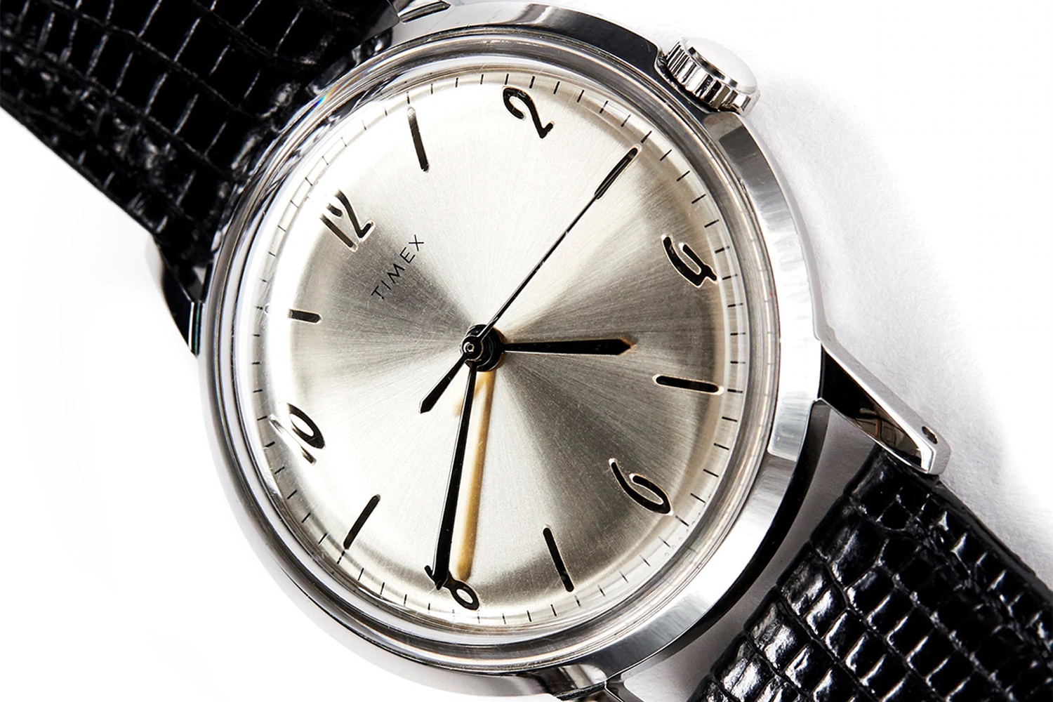 A silver faced Timex+Todd Snyder watch on a white background