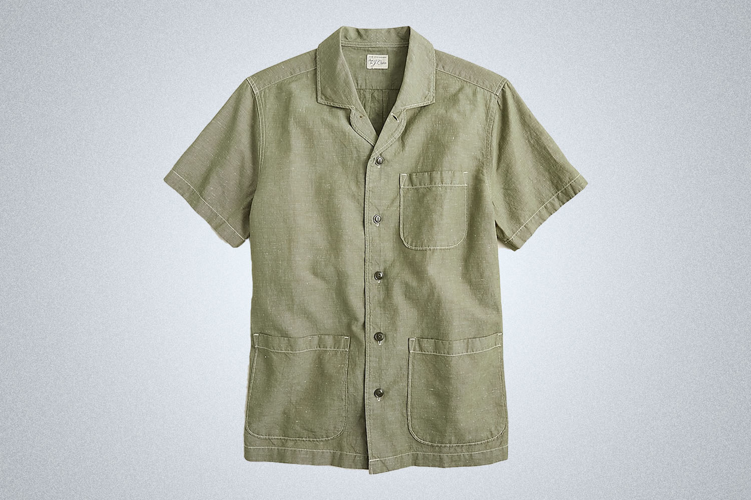 a green short sleeve button-up on a grey background